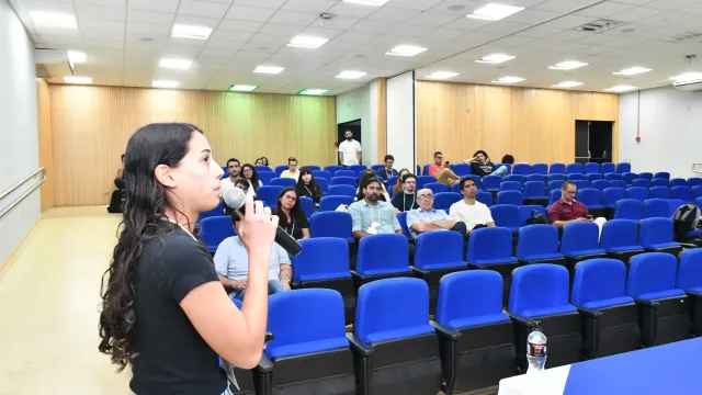 Mulher faz apresentação em auditório cheio