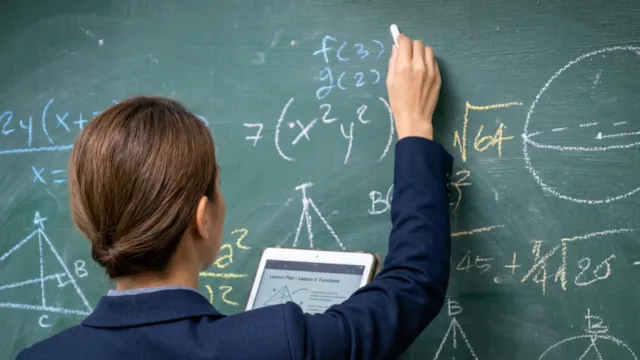 Professora escreve no quadro em aula de Matemática