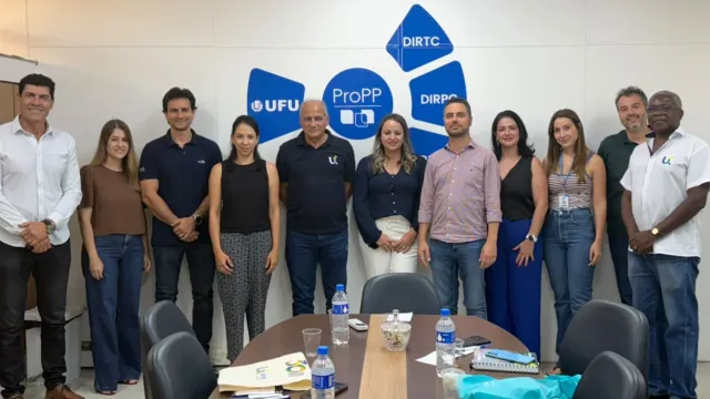 Grupo de pessoas reunidas na sala de reunião da Pró-reitoria de Pesquisa e Pós-graduação da UFU.